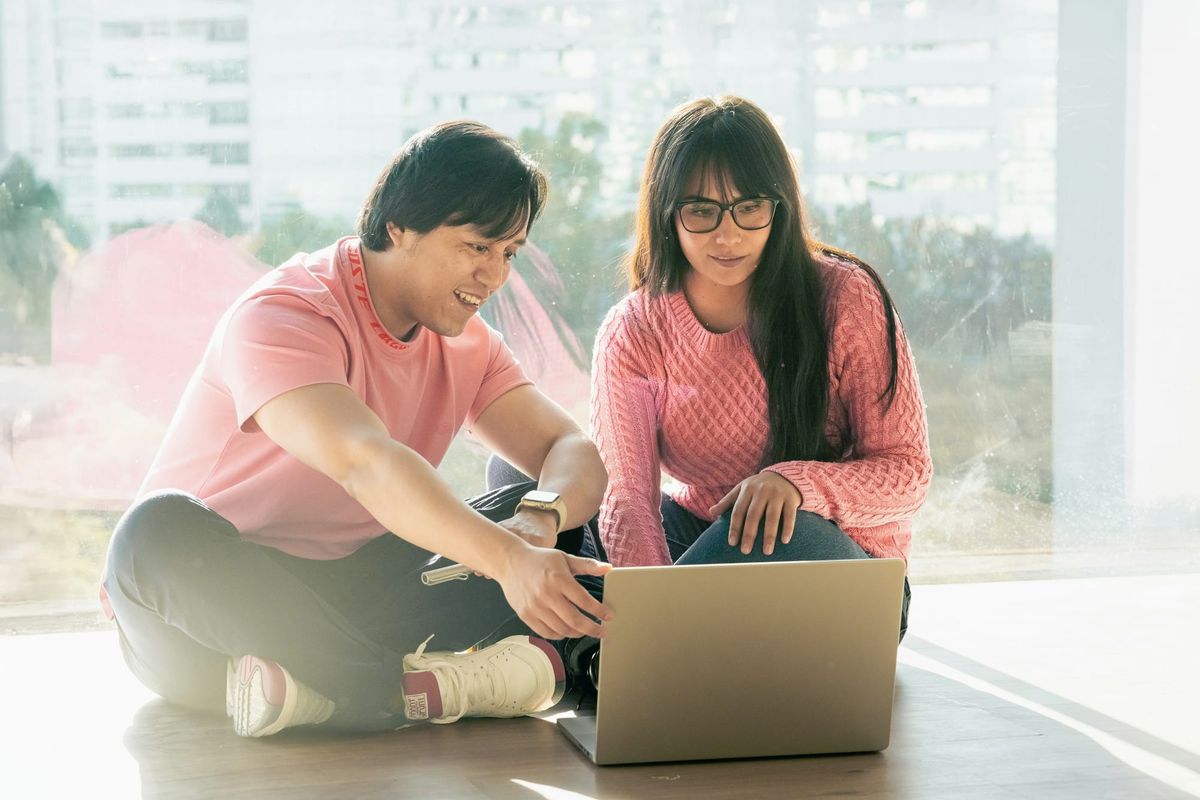 man and woman on a laptop - How to Automatically Move Emails to a Folder in Gmail
