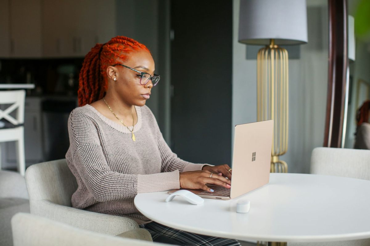 woman using a laptop - Microsoft Loop vs Notion