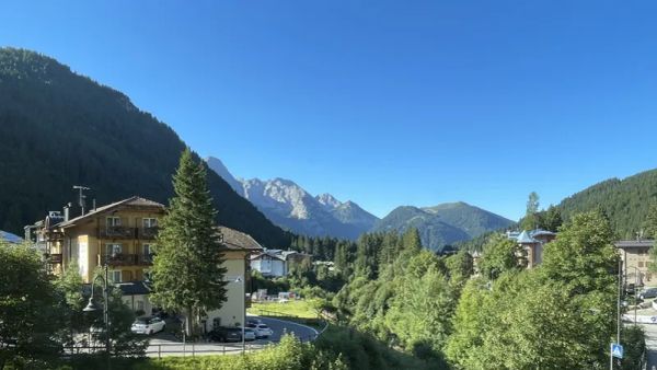 A scenic picture of the Dolomite mountains in the background against a strong blue sky