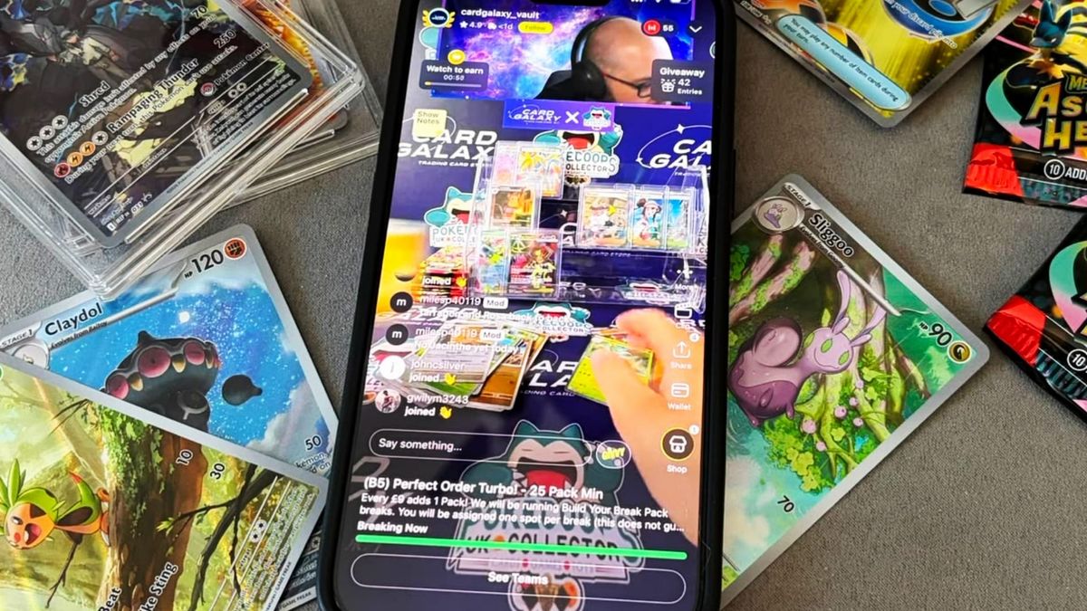 A phone screen with a Whatnot stream playing, with a variety of Pokémon cards surrounding it on a desk