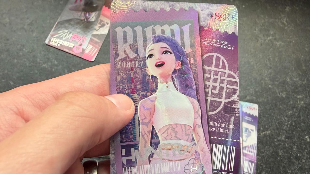 A hand holding a Rumi SSR card from Kayou's KPop Demon Hunters Collectible Trading Cards