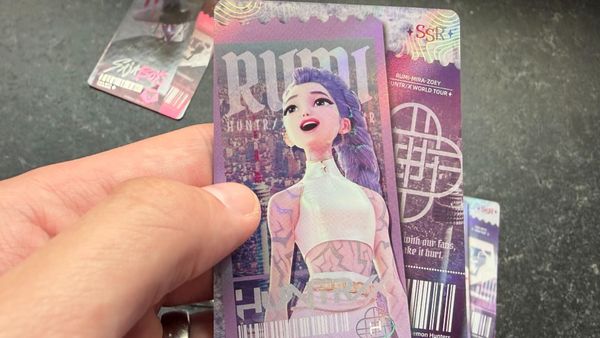 A hand holding a Rumi SSR card from Kayou's KPop Demon Hunters Collectible Trading Cards