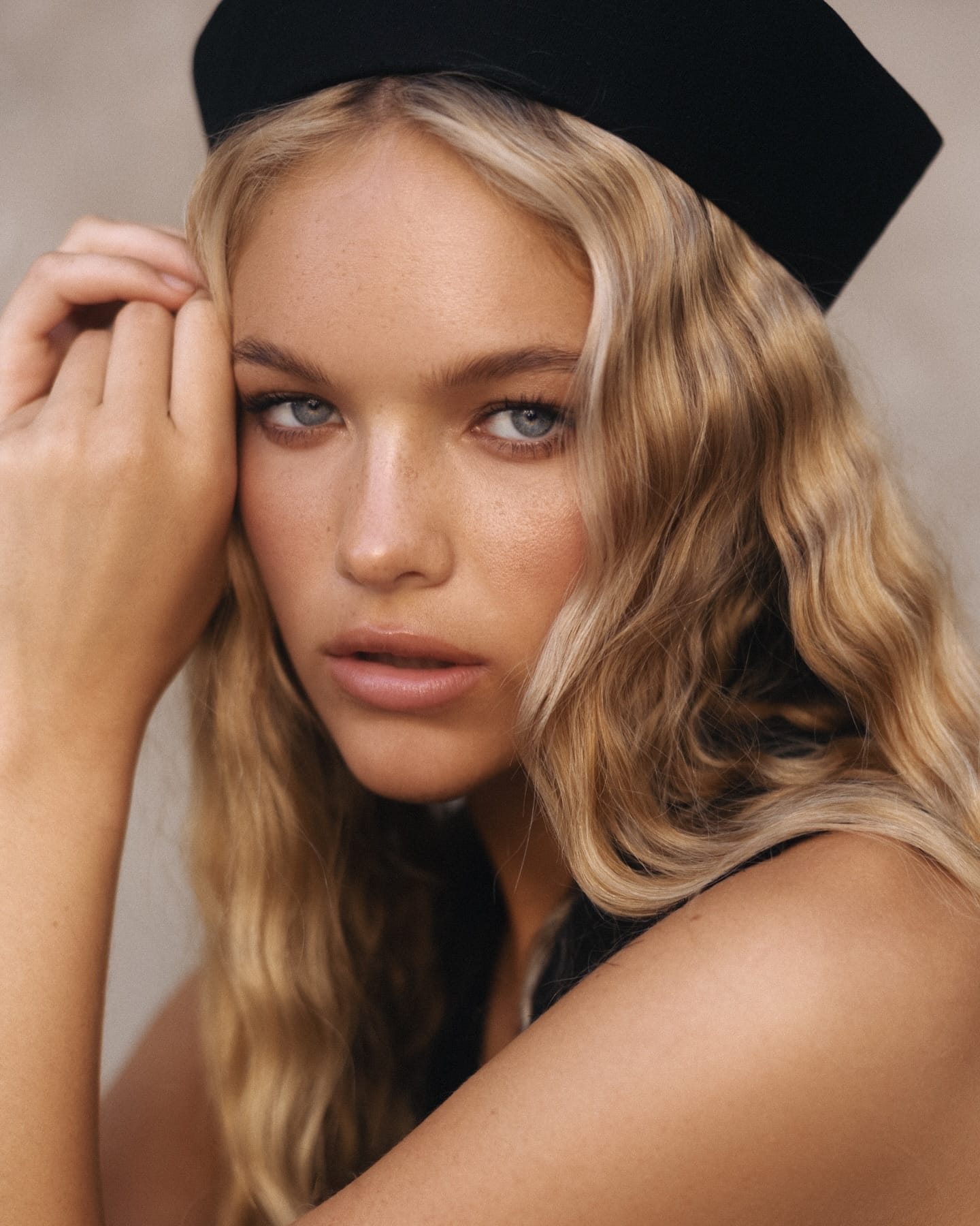 Close beauty portrait of Cadence van Hoften in a pillbox hat, freckles visible across her nose, photographed by Olga Aleshina.