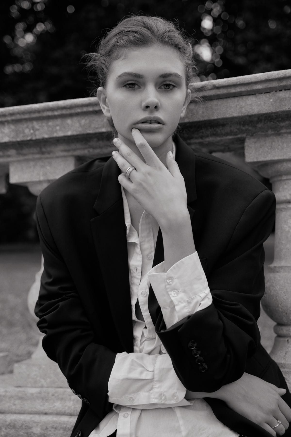 Close portrait of Alyona Lihosherstowa with a finger touching her lower lip, an oversized black blazer over a white shirt, photographed by Alexei Bazdarev.