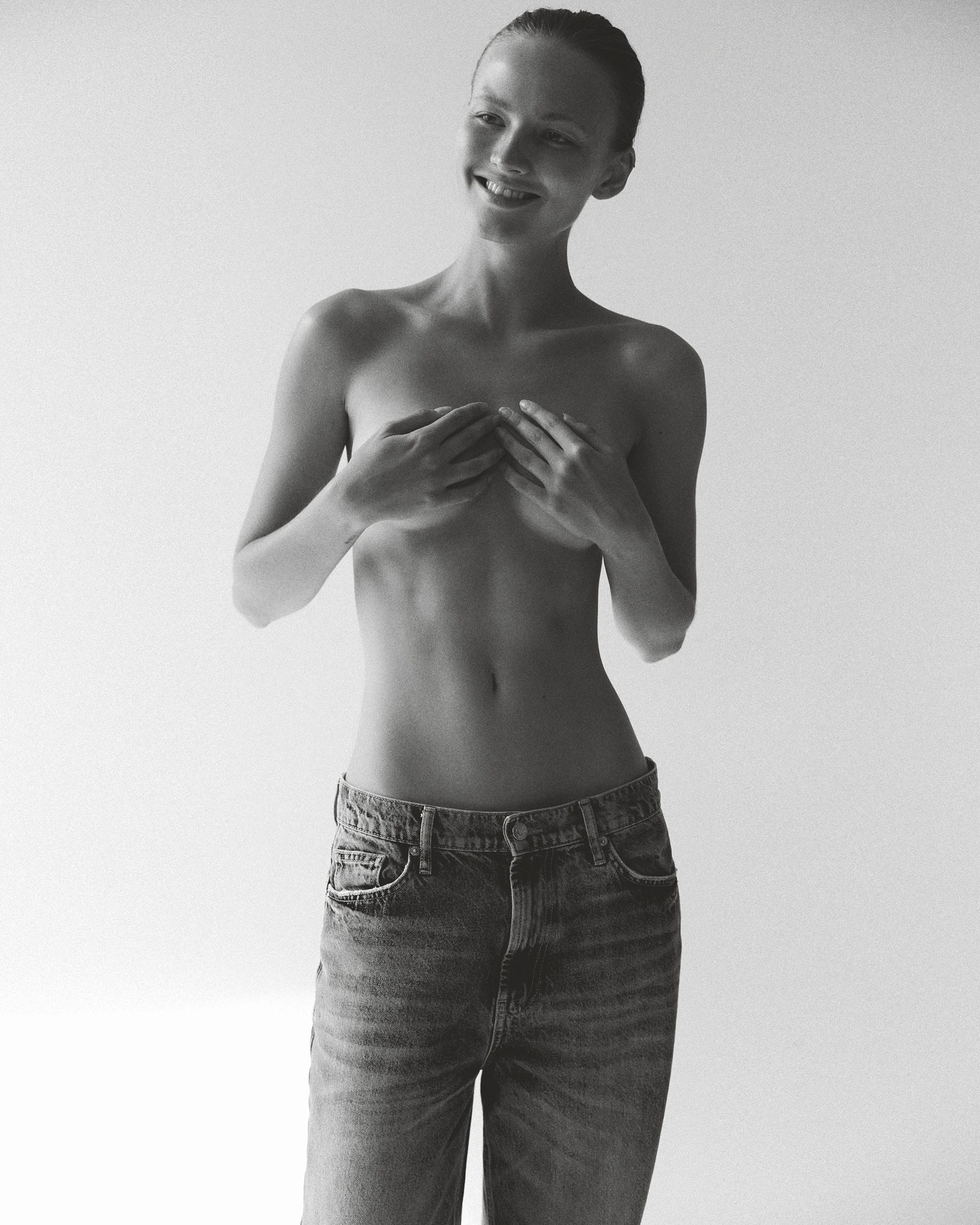 Tanya Korné laughs with both hands gathered loosely at her chest, photographed by Darya Abramova.