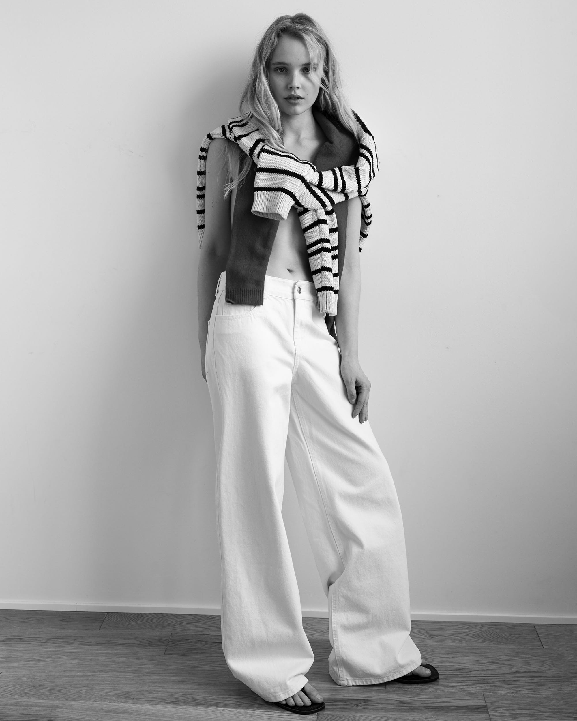 Jeanne Markevich in a red vest with striped sweater knotted at the shoulders and white jeans, by Kristina Ranneva.