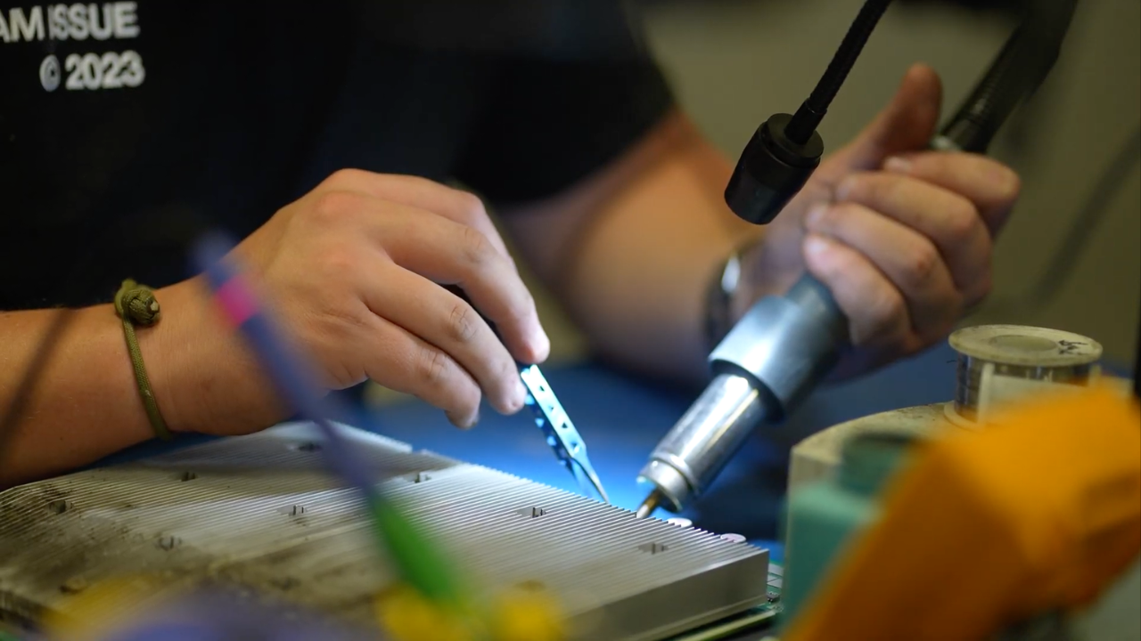 Technician soldering an ASIC miner control board at Simple Mining's Bitmain-certified repair facility in Cedar Falls, Iowa.