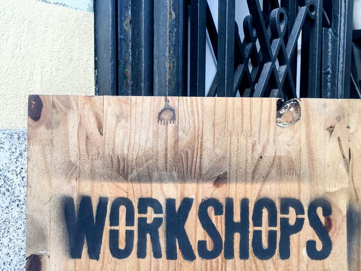 plywood board with "workshops" stenciled on it