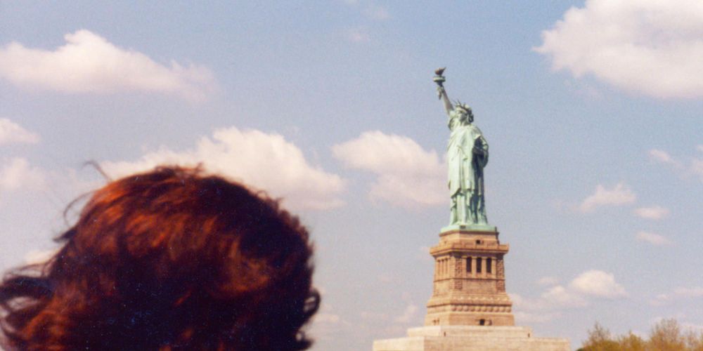 Immigrant looking upon the Statue of Liberty / iStock