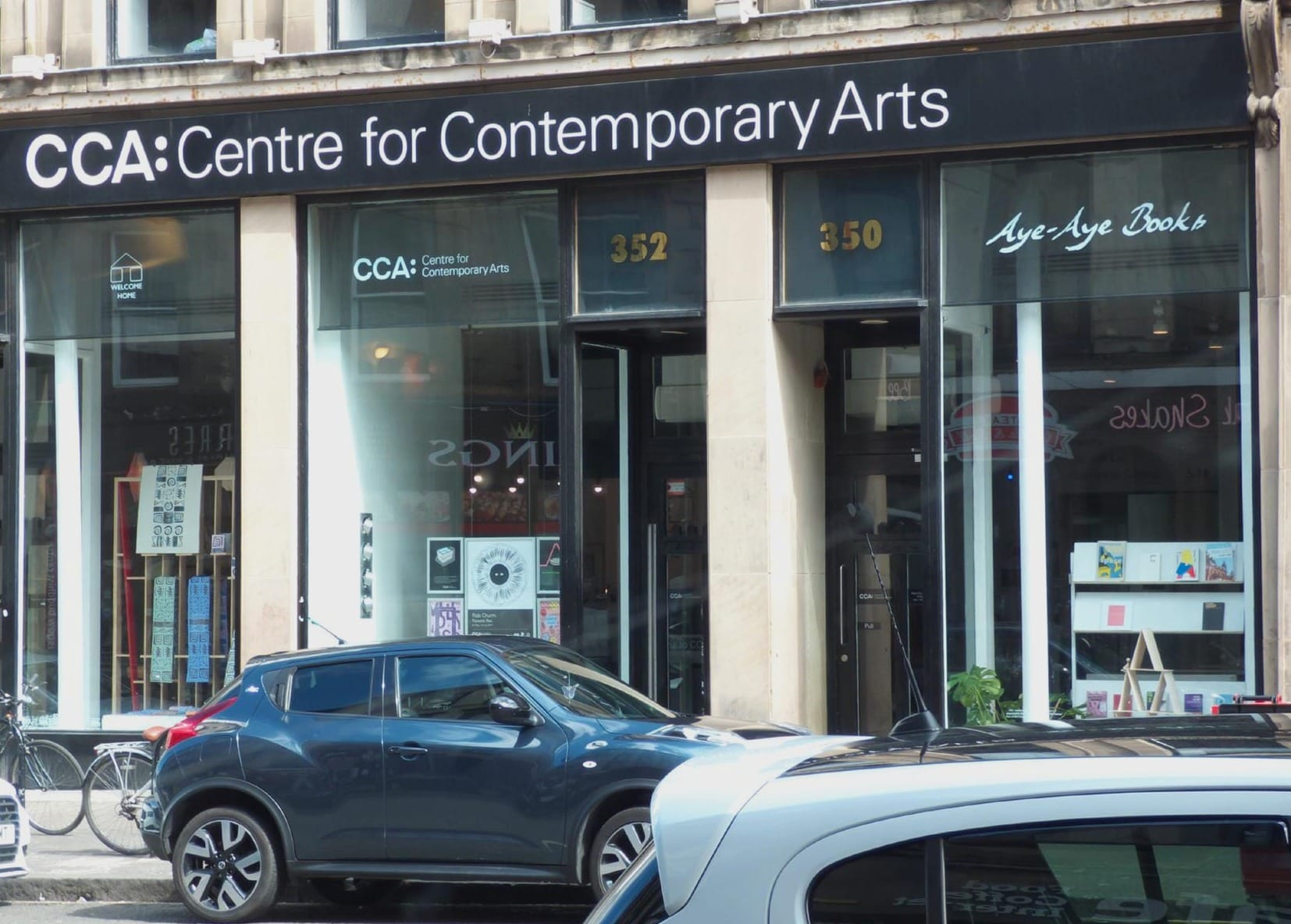The frontage of the Centre for Contemporary Arts in Glasgow as seen from Sauchiehall Street. Two sandstone columns with an entrance either side and the sign for the CCA in black above. 