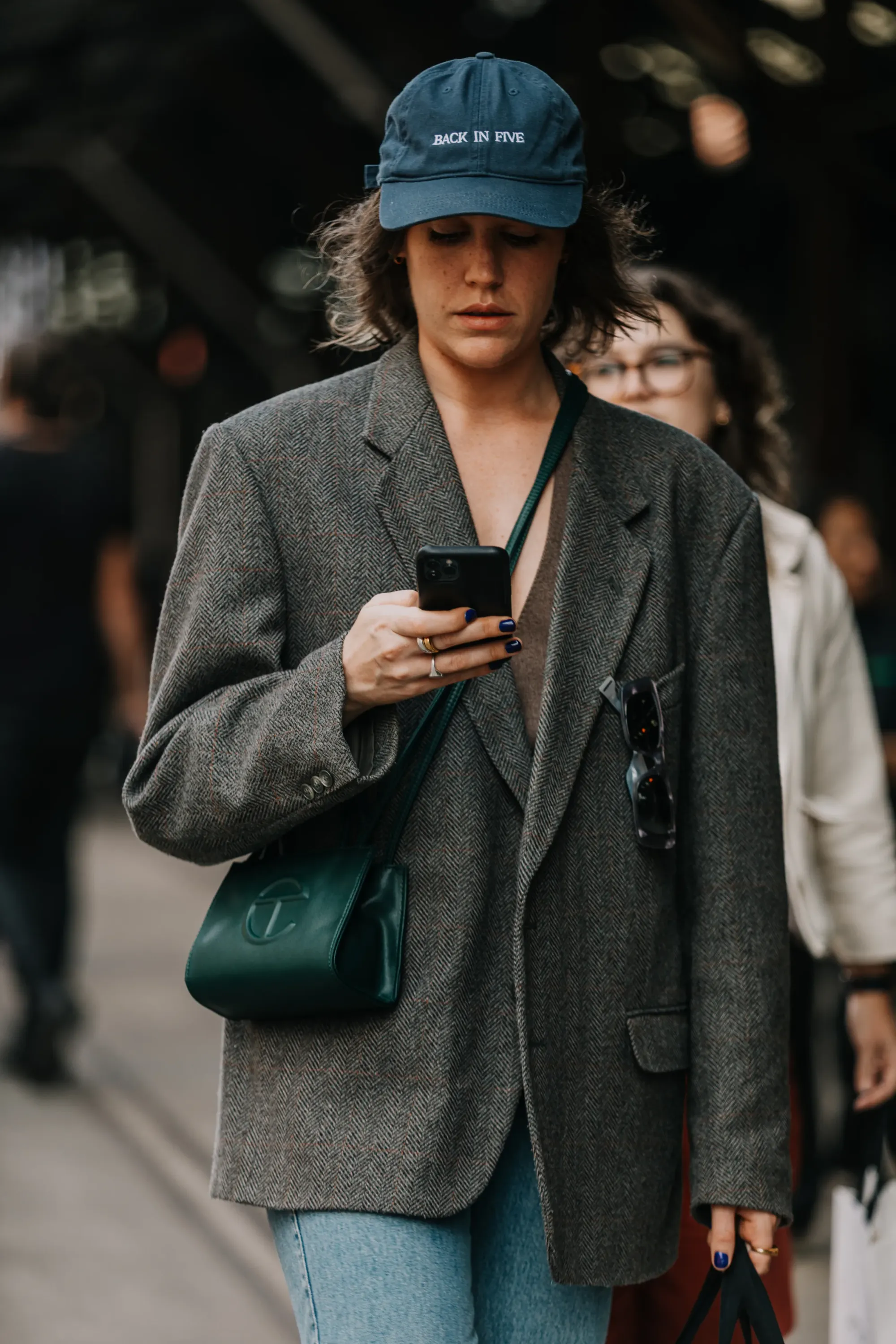Street style model wearing Telfar bag, oversized blazer and a cap.