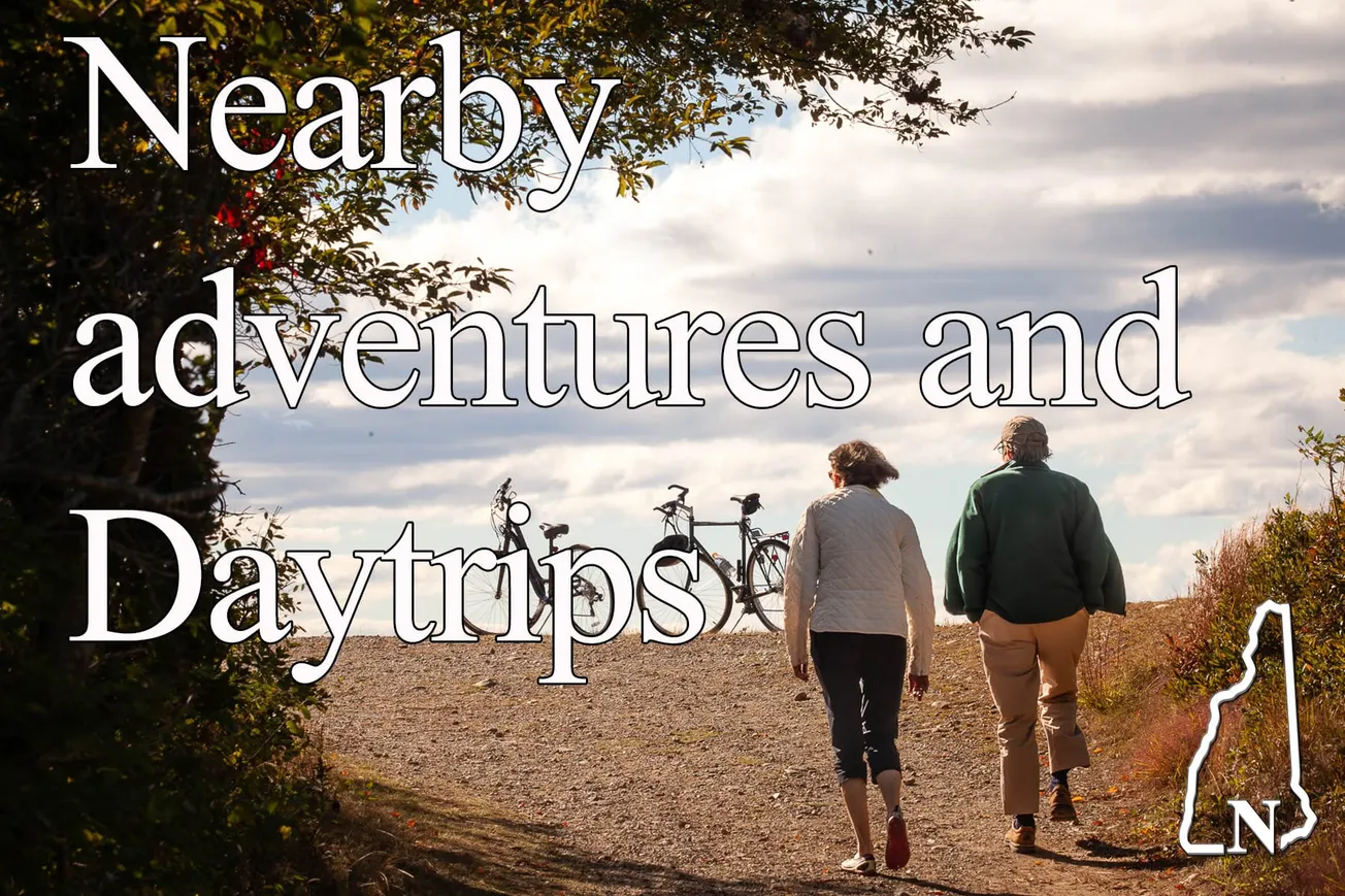 Two people walking bikes on a tree-lined path in Nashua, with text overlay "Nearby adventures and Daytrips"