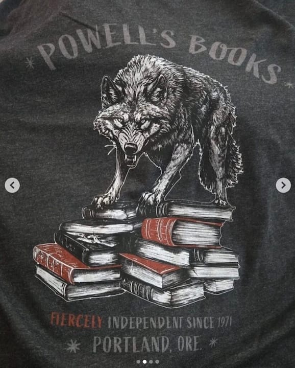 an AI-generated image of a wolf snarling atop a stack of books. below the image are the words "fiercely independent since 1971 * Portland, Ore. * "