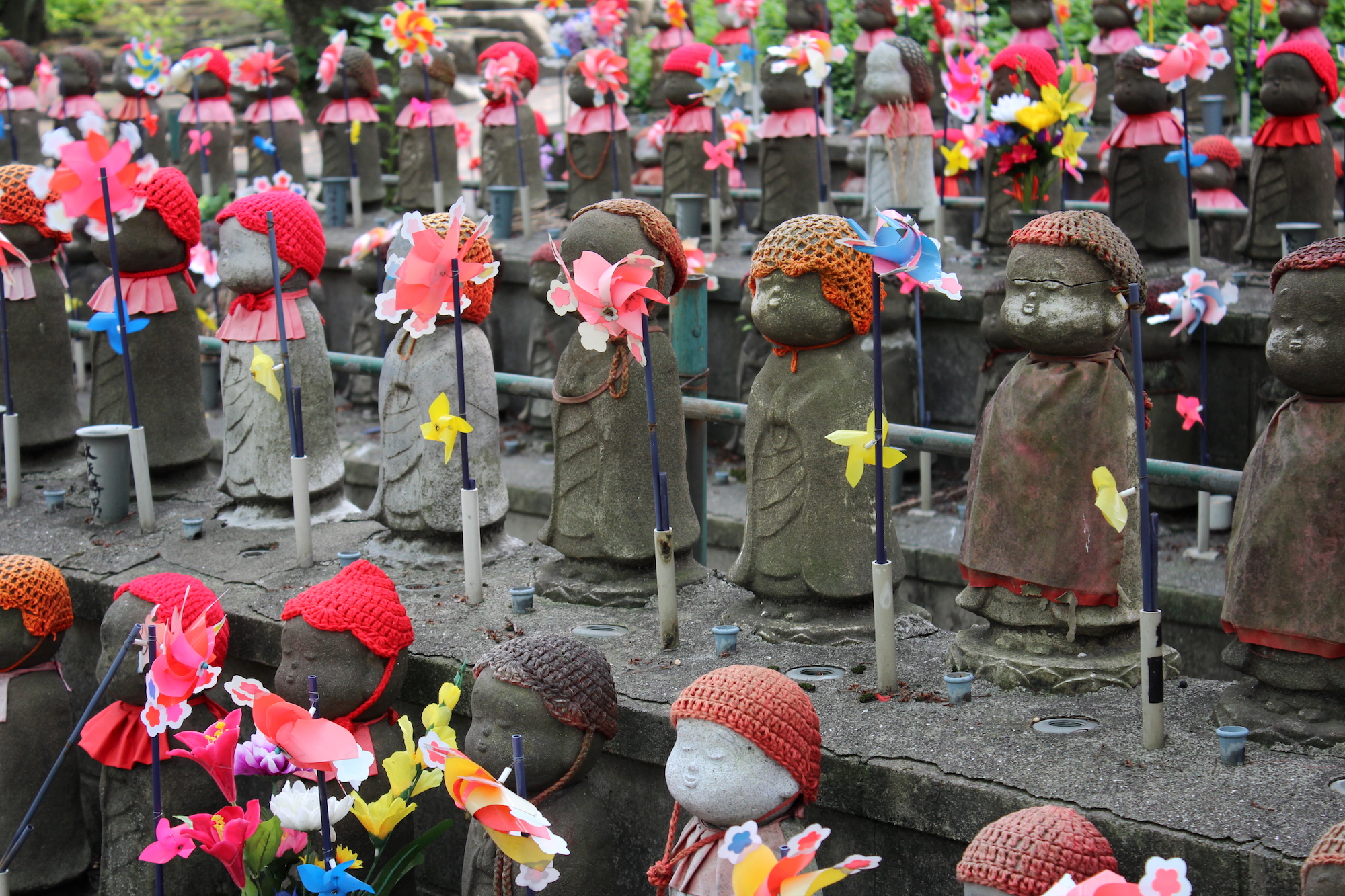Rows of small statues with handmade bonnets