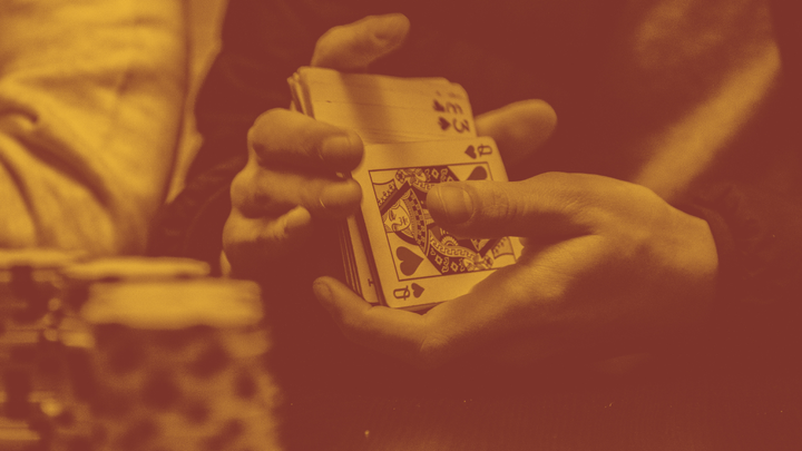 A photo of a man's hands shuffling a deck of cards.