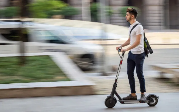 jeune homme faisant de la trottinette dans la rue
