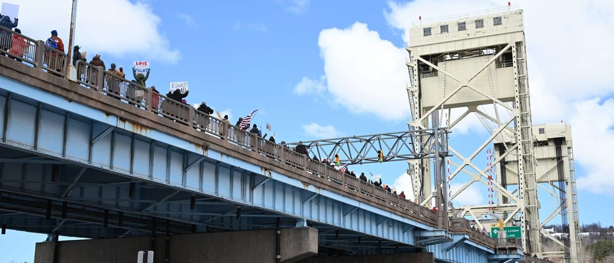Hundreds of community members lined up on both sides of the lift bridge in Houghton for a "Hands Off" rally.