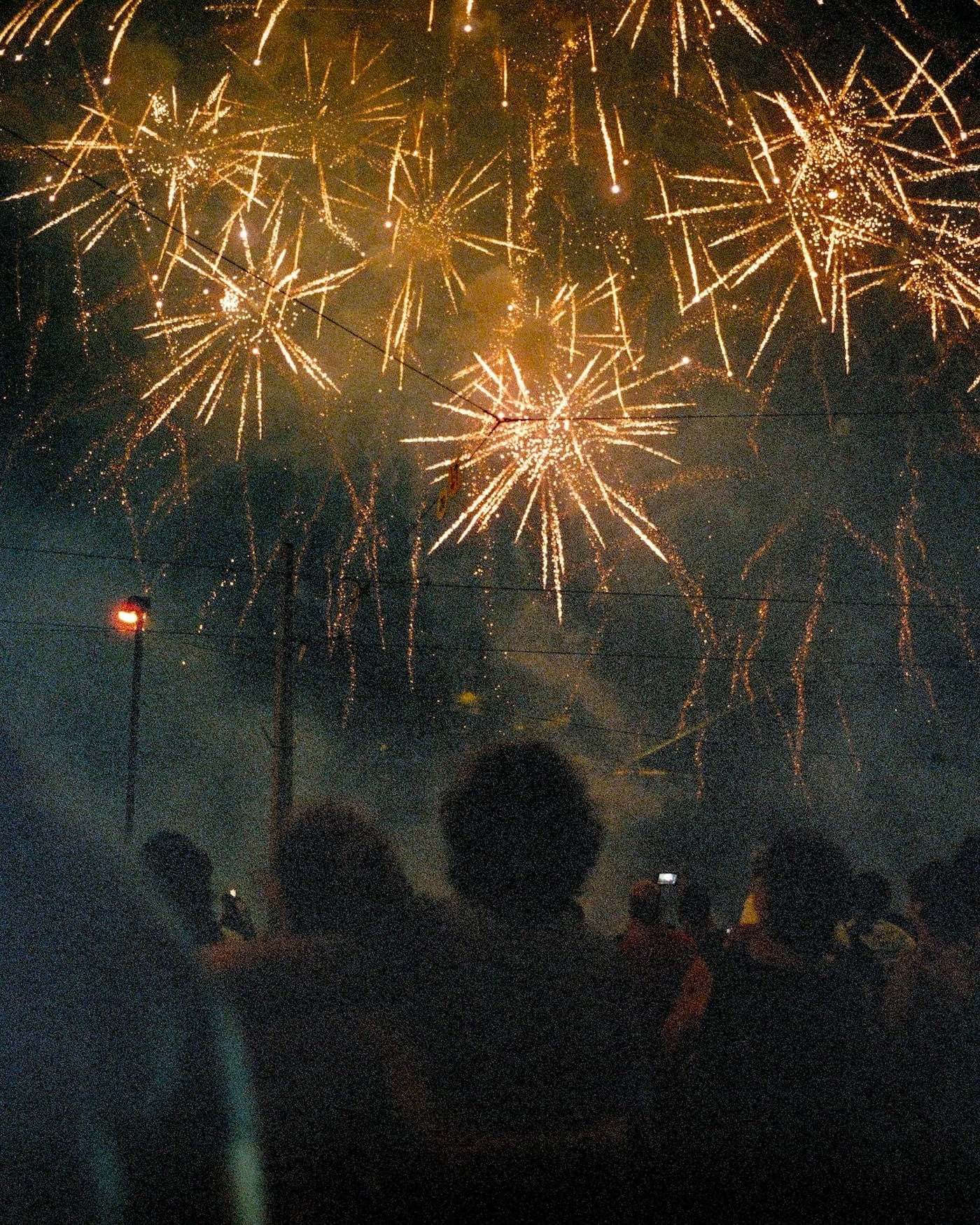 Spectacular golden fireworks bursting in the night sky during a celebration.