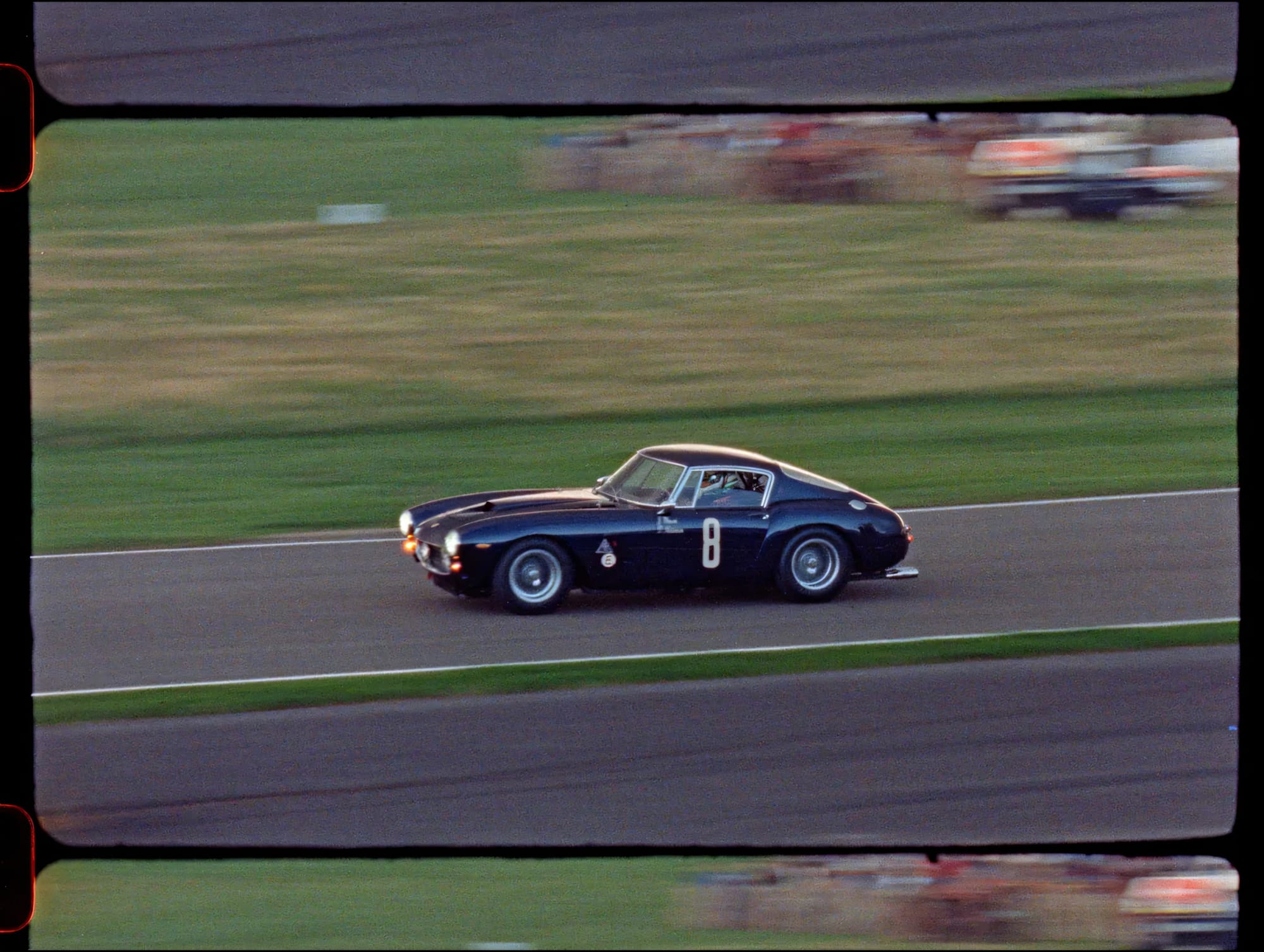 Black racing coupe on track with motion blur.