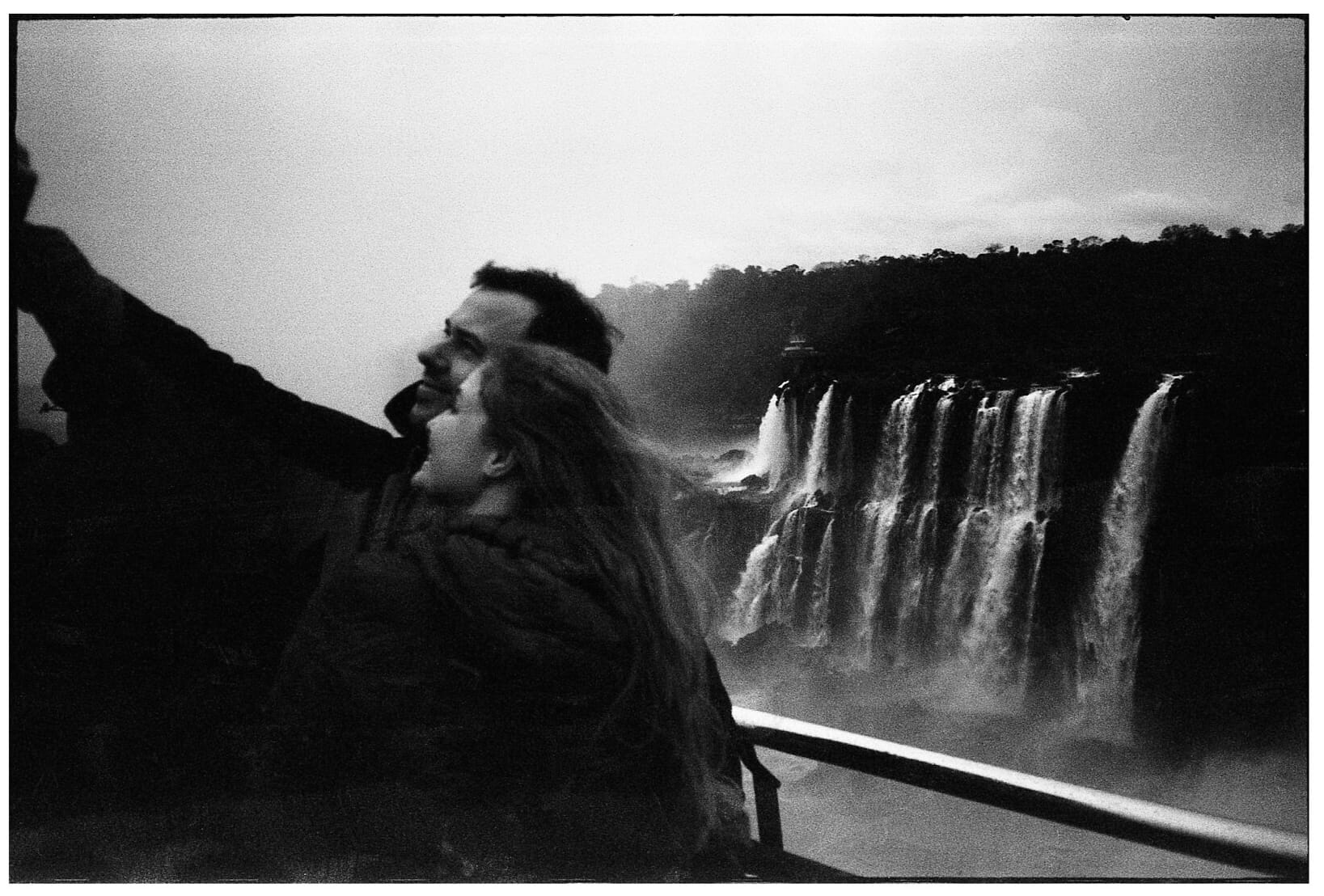 A smiling couple taking picture at waterfall overlook.