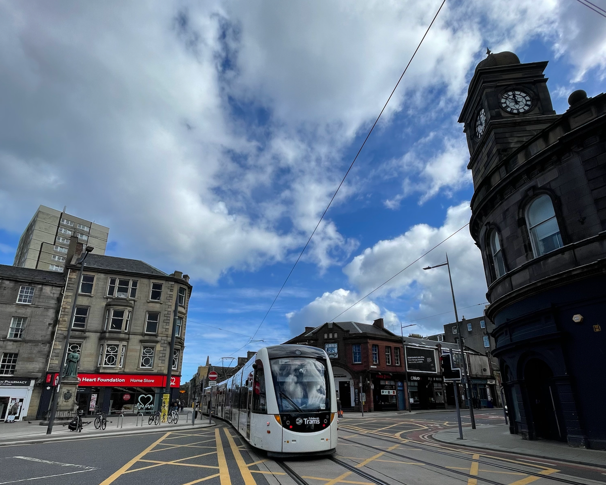A tram passing shops. 