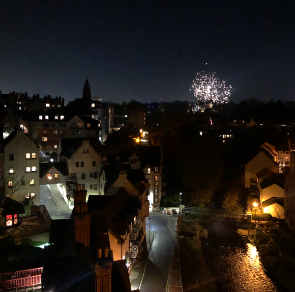 A firework going off above a city skyline at night.