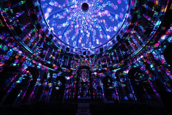Multi-coloured lights on the ceiling and walls of a large room. 