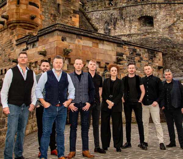 A group of people standing in front of a castle. 