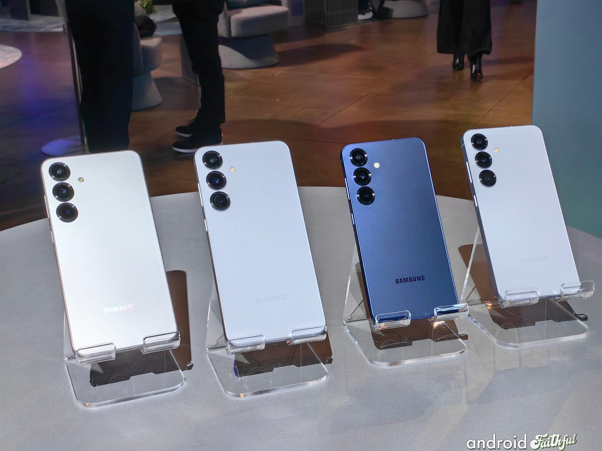 Galaxy S25 and S25+ sit on stands on a table.