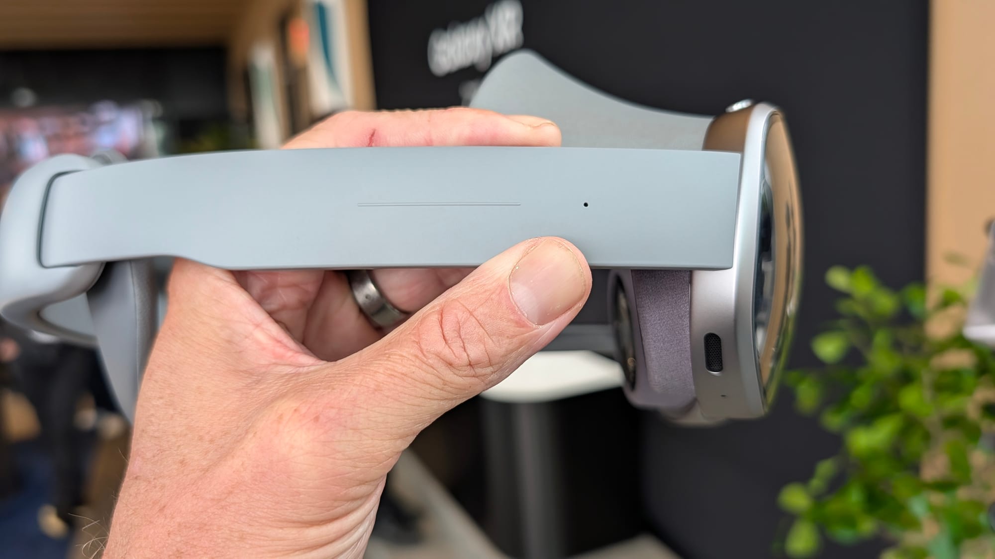 A photo of a person holding up the Galaxy XR, side view.