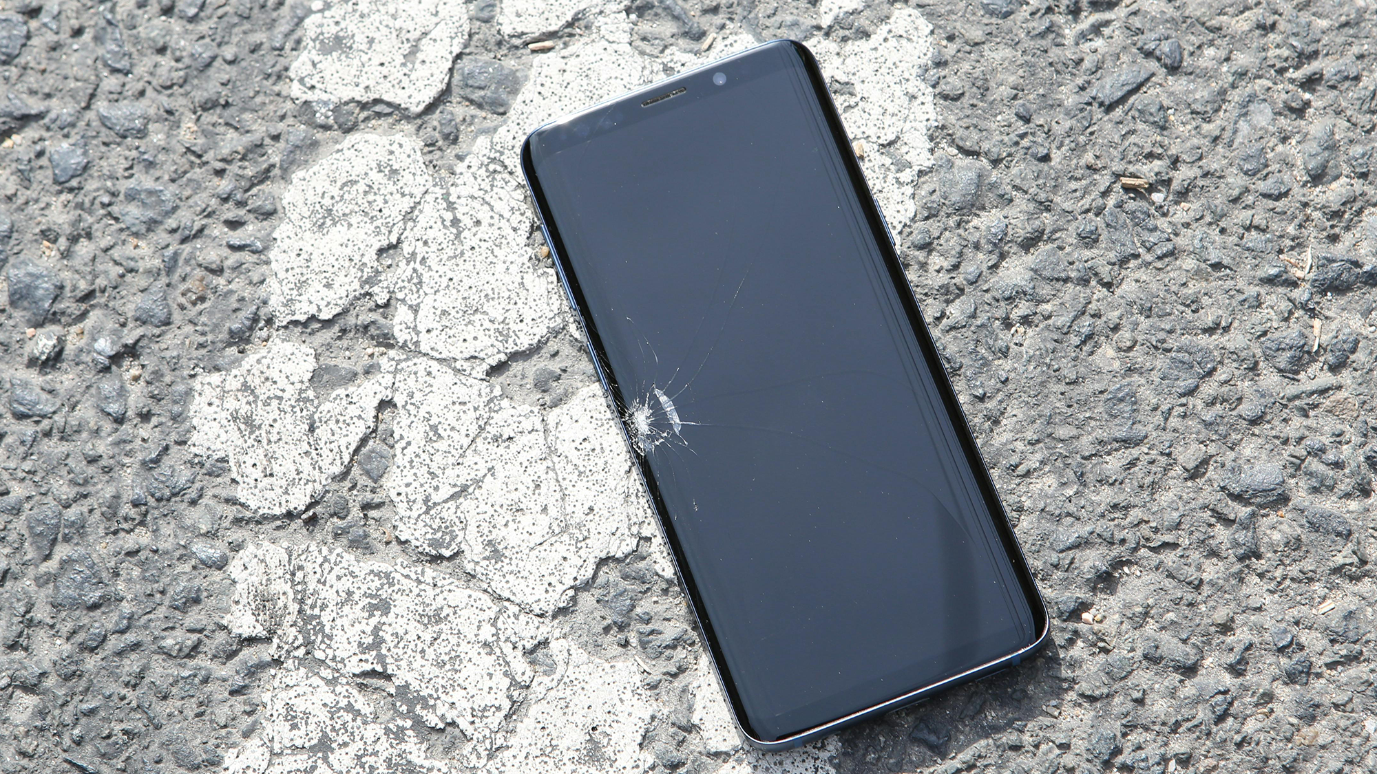 A photo of an older model Samsung phone with a cracked display