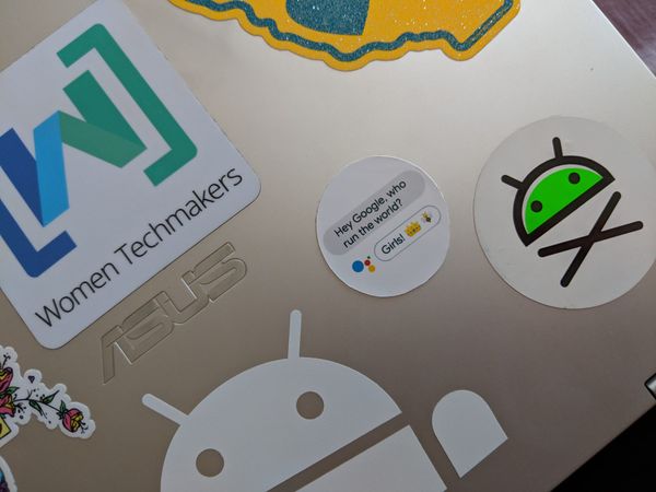 A photo of a laptop with a bunch of stickers on it. 