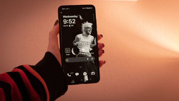 A photo of a person holding the OnePlus 13 with OxygenOS 16 loaded onto it