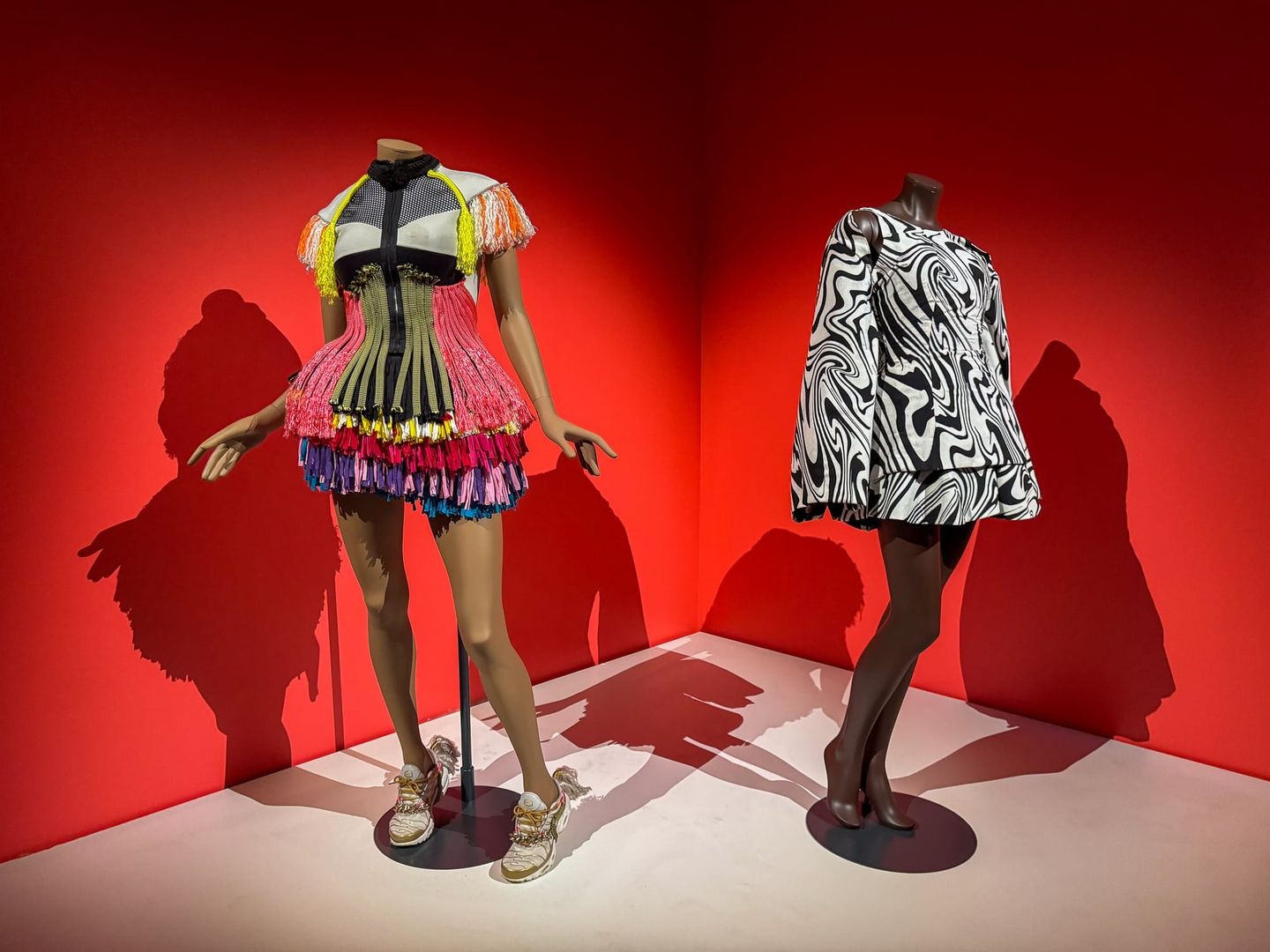 Side view of two bold dresses from the Africa Fashion showcase, highlighting vibrant textures and experimental silhouettes.