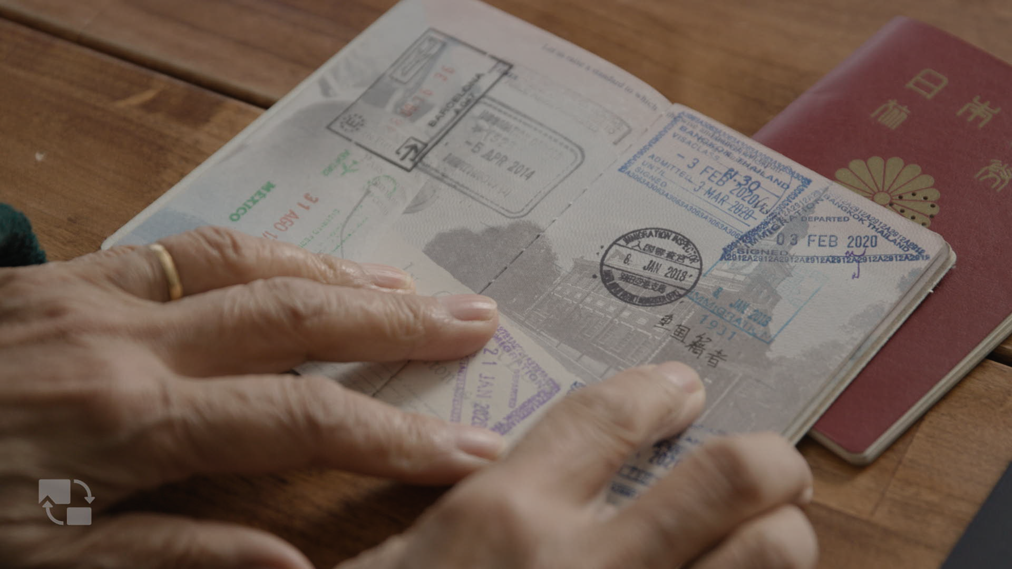 Hands holding an U.S. passport open to a stamped page.