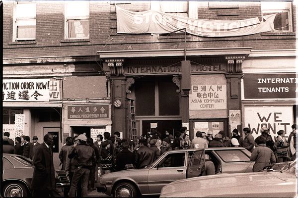 Black and white photo of dozens of people standing in front of the I-Hotel in 1977. Credit: Nancy Wong