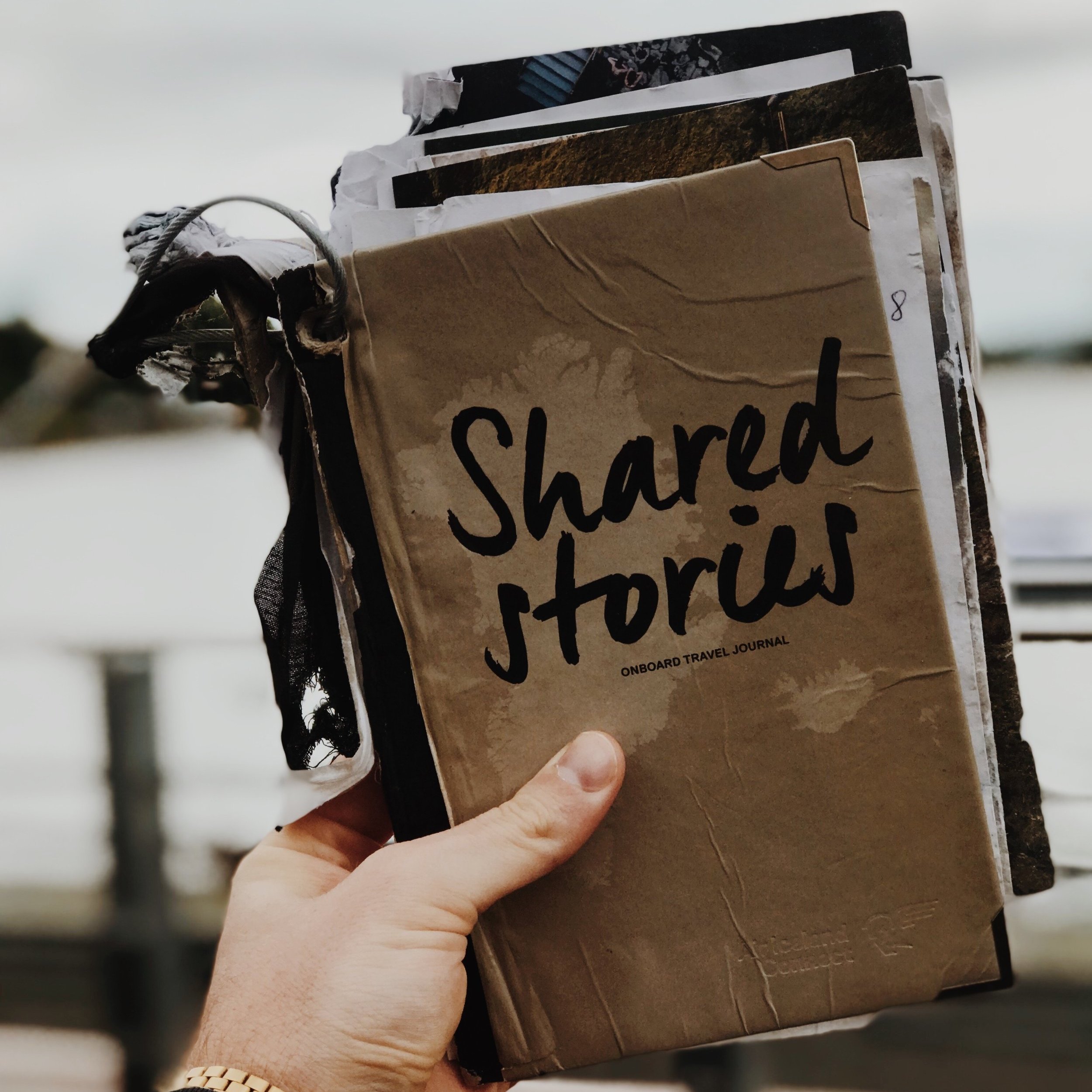 Someone holding a journal titled "Shared Stories"