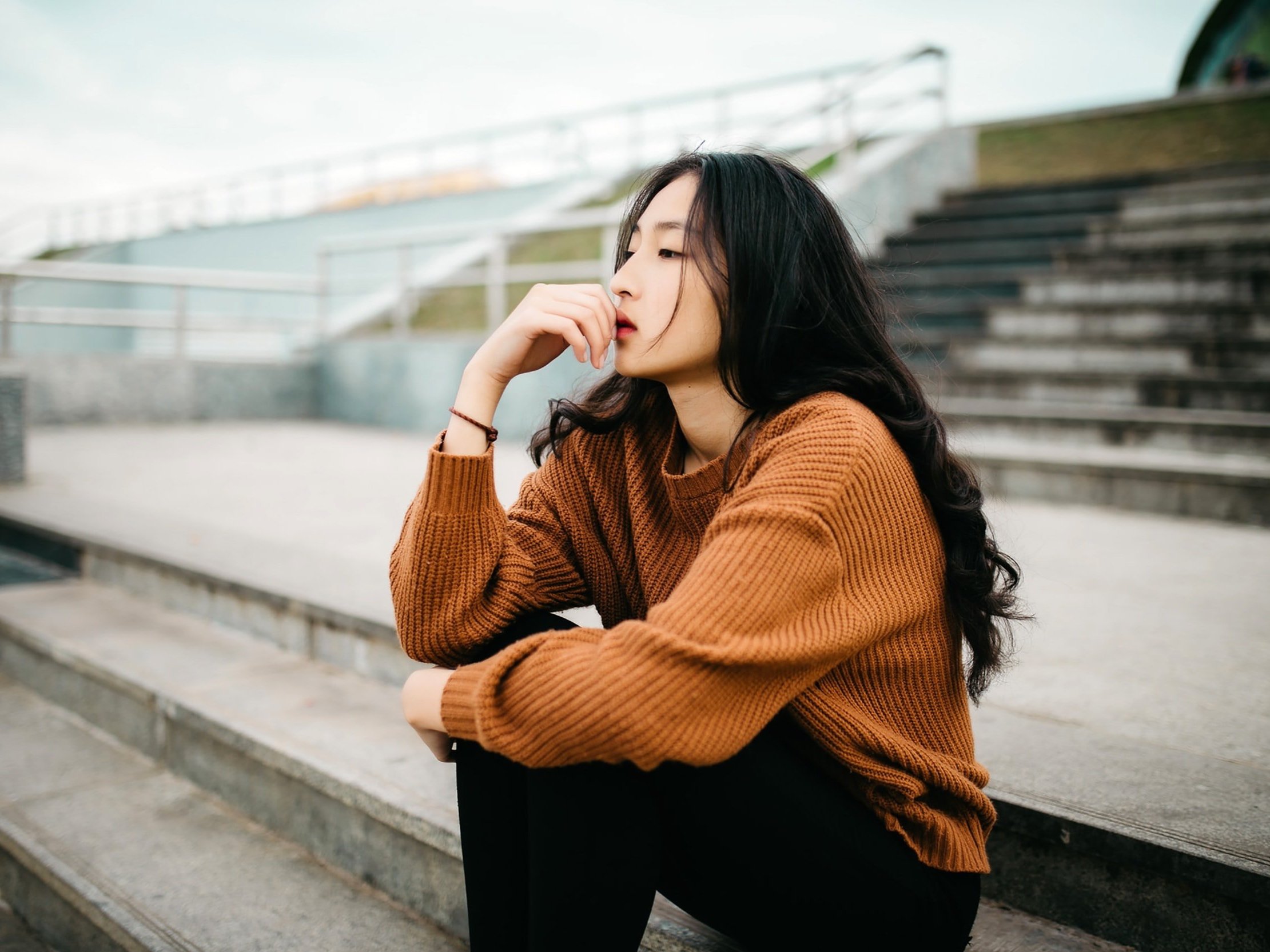 A young lady sits down and takes a moment to reflect.
