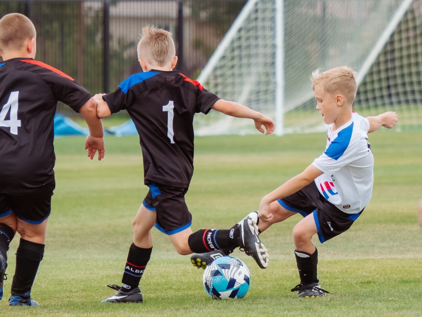 Football is being played by a group of young children.