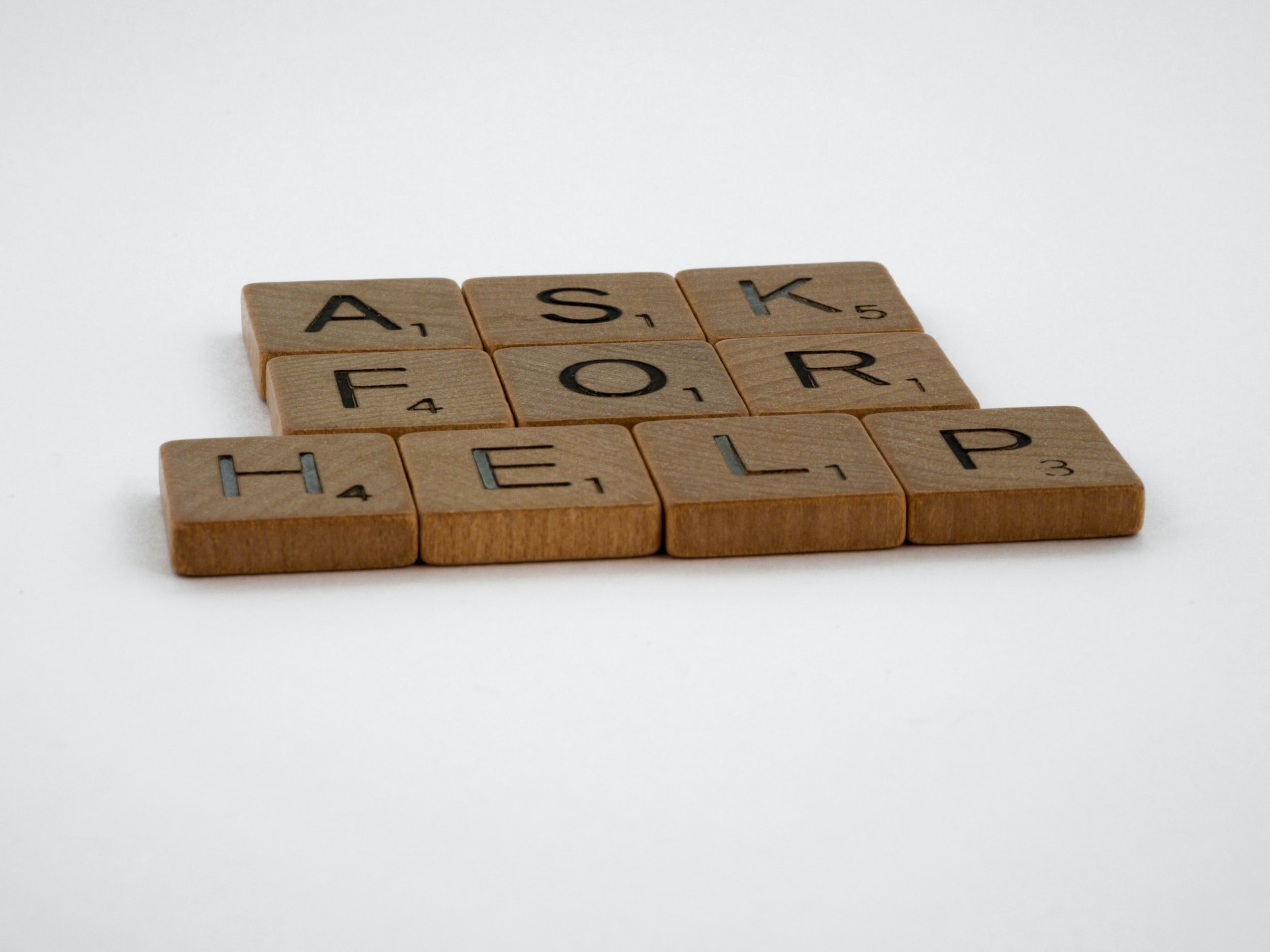 "Ask For Help" is written in wooden letter tiles.