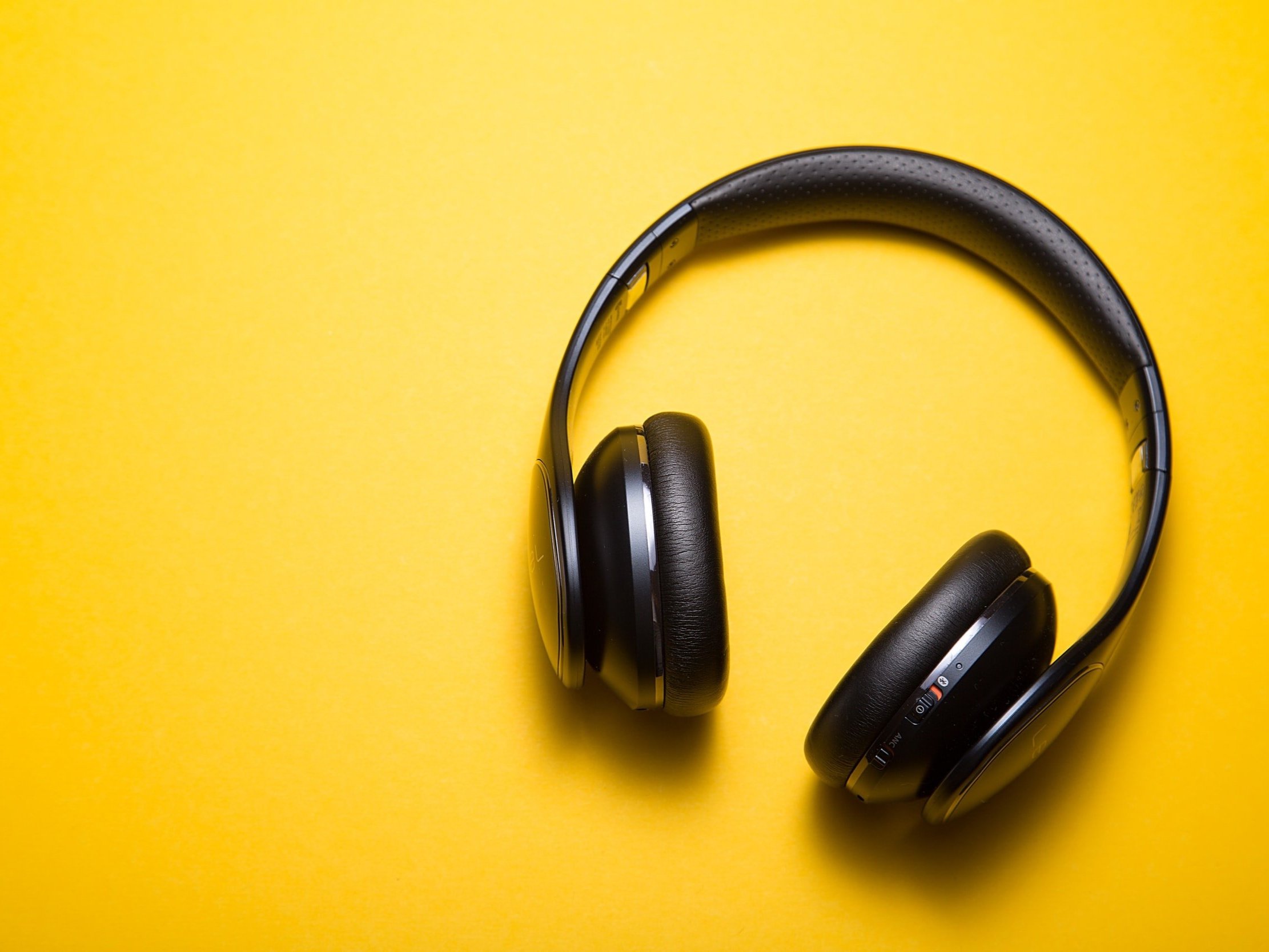 Bluetooth wireless headphones on a yellow background.