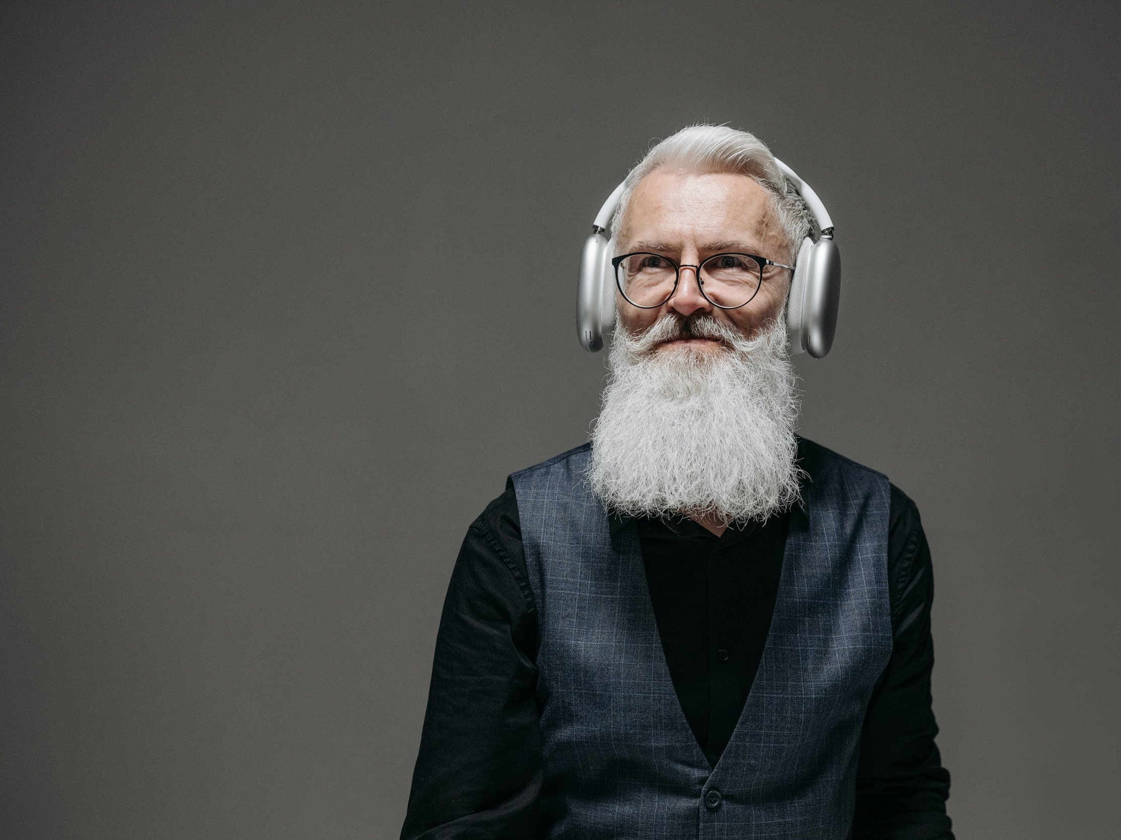 With a smile, a man listens to music on a pair of wireless headphones.