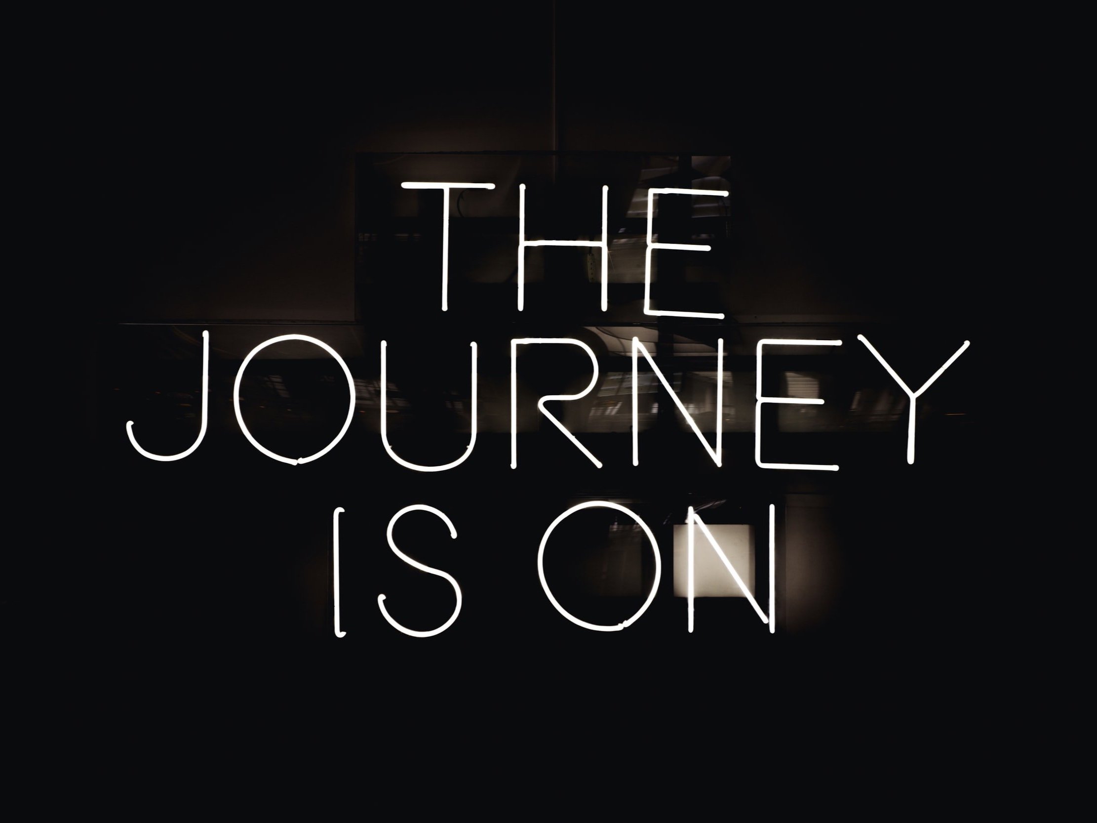 Neon lights spelling out "The Journey Is On"