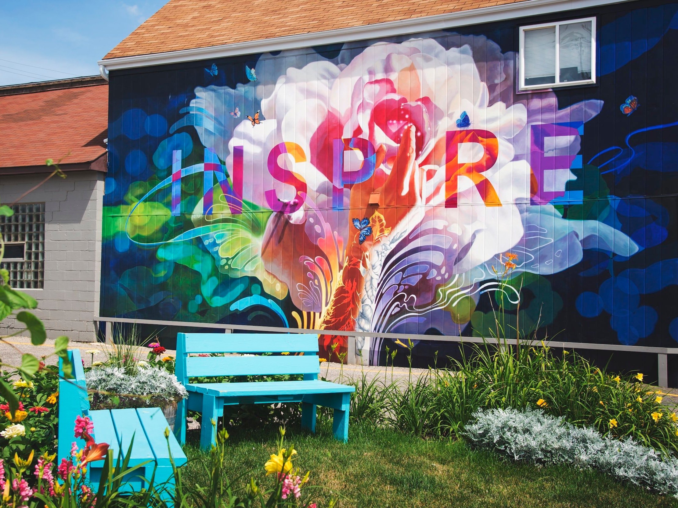 On the side of a building, a mural with the word "Inspire" is painted.