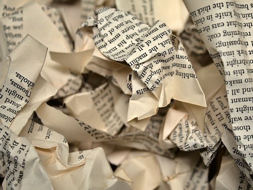 A heap of crumpled paper containing printed type.