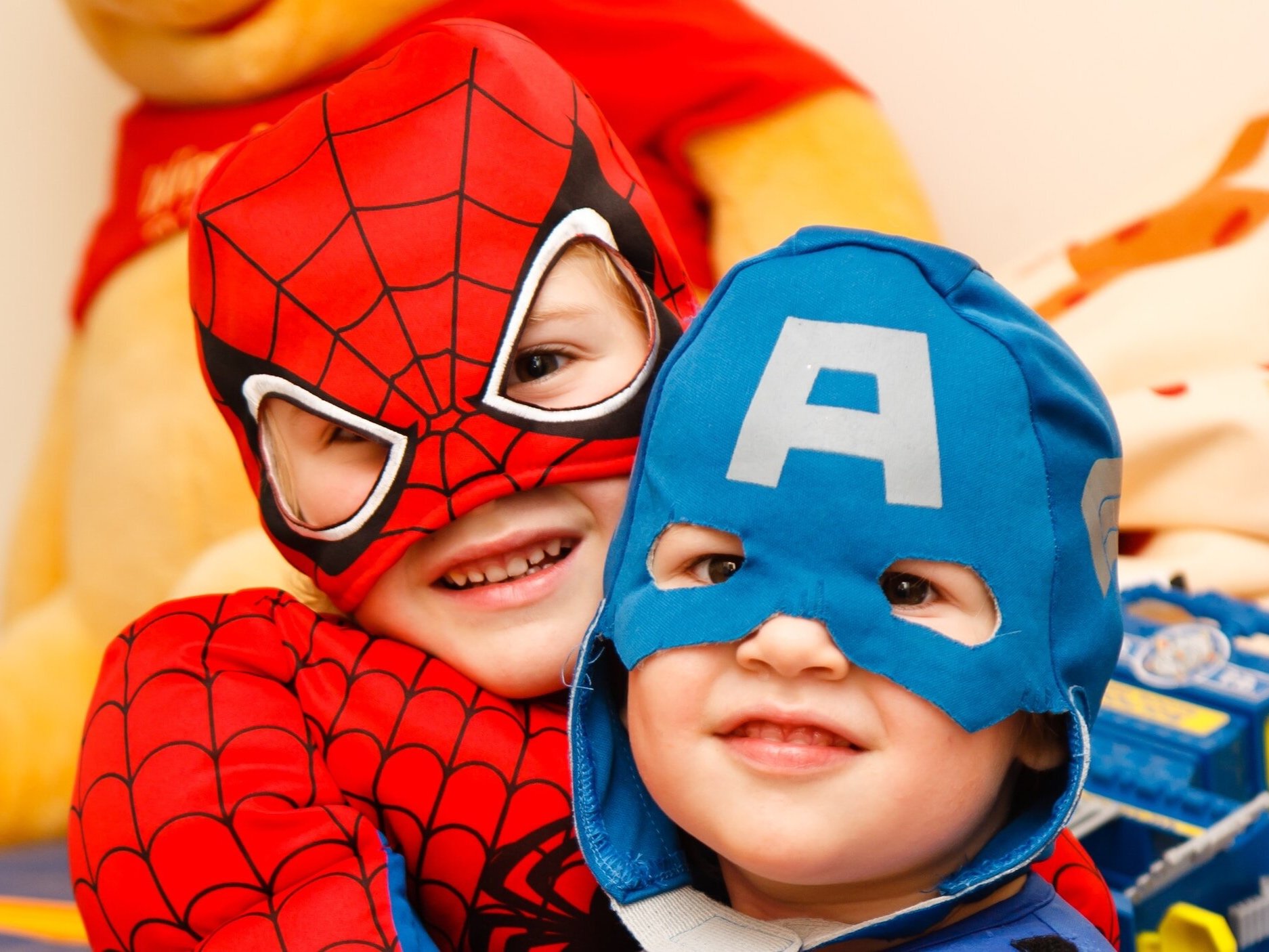 Two young children dressed as superheroes.