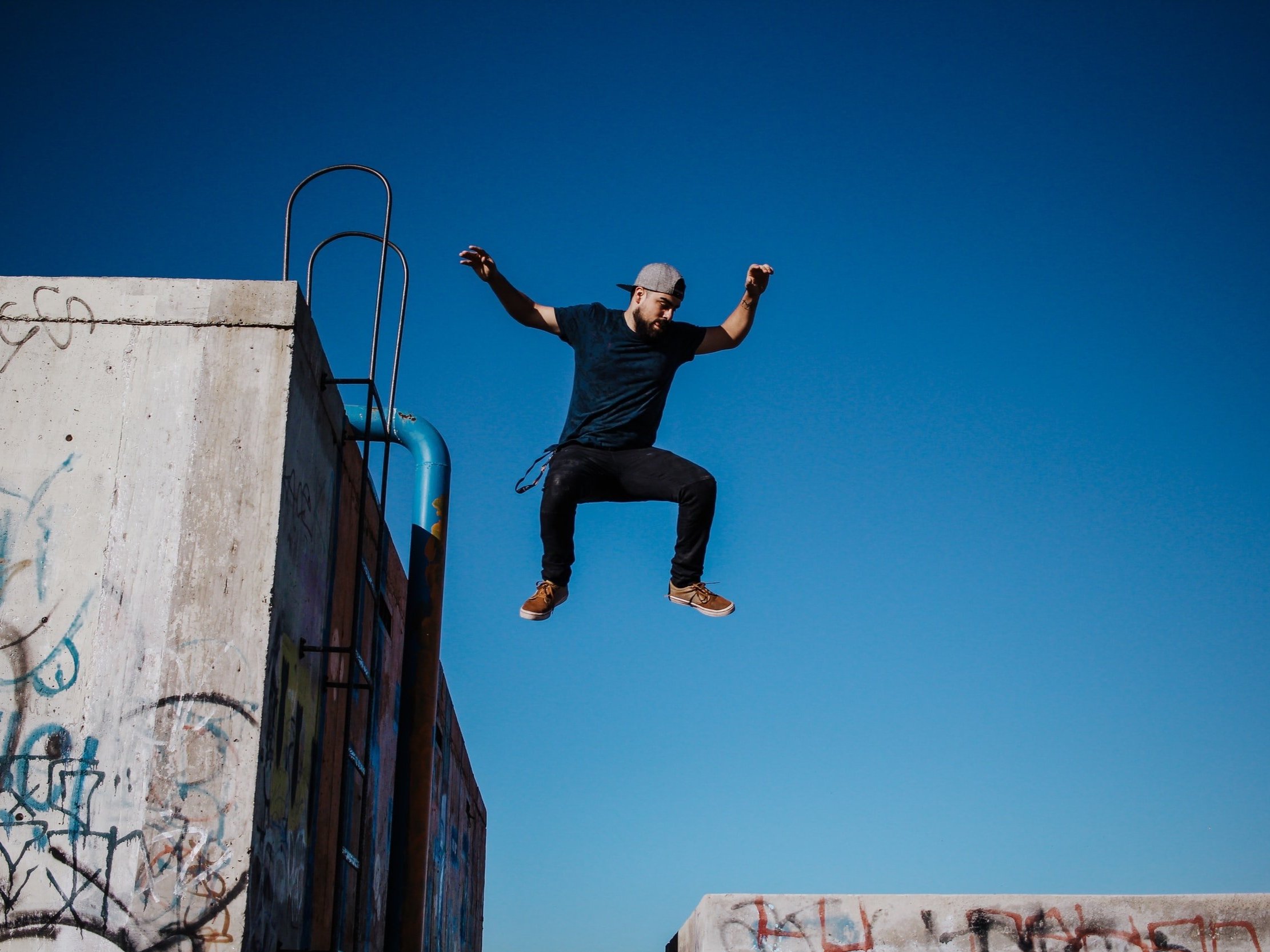 A man leaps from one concrete block to the next.