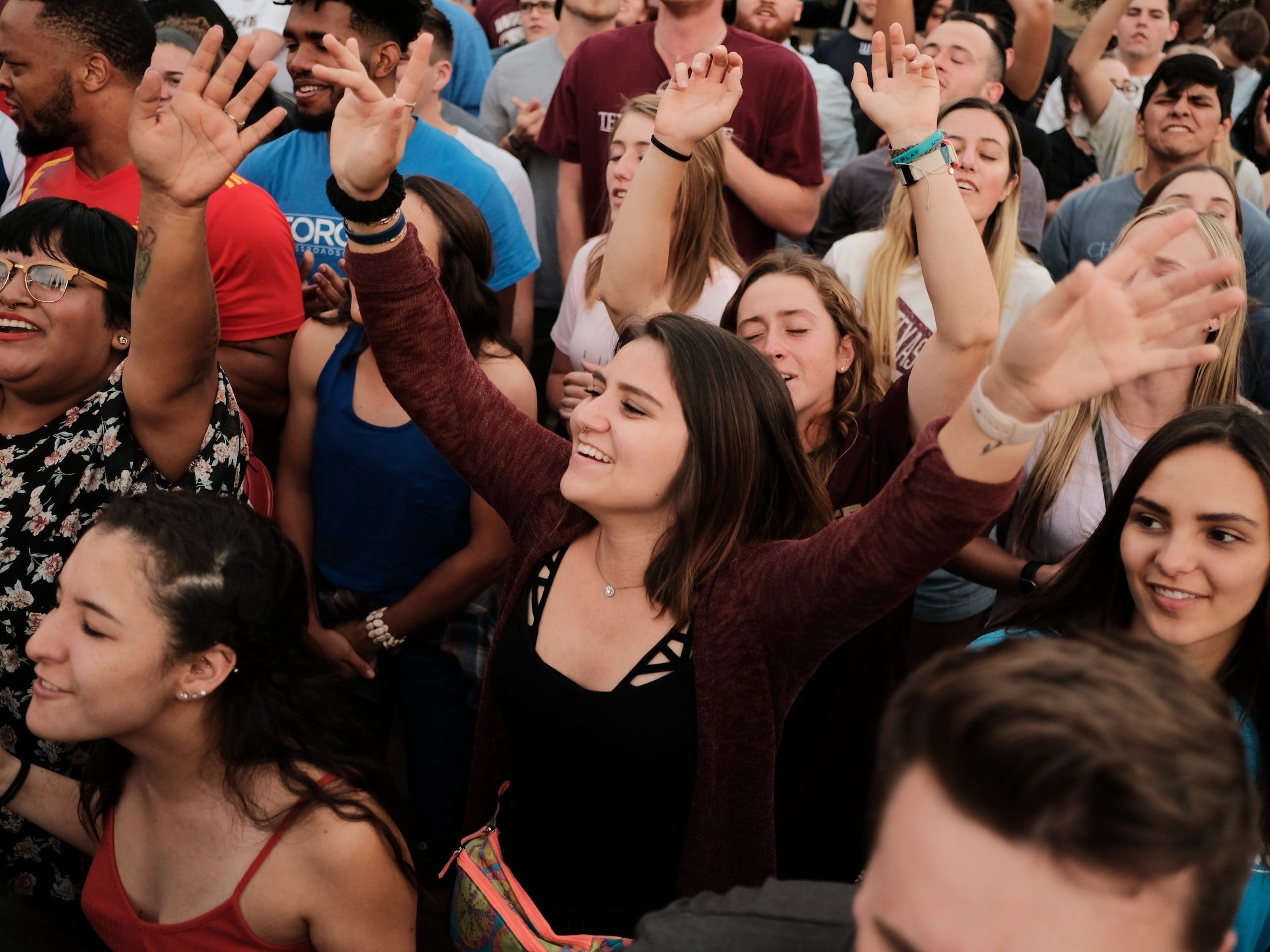A cheering crowd with their hands in the air