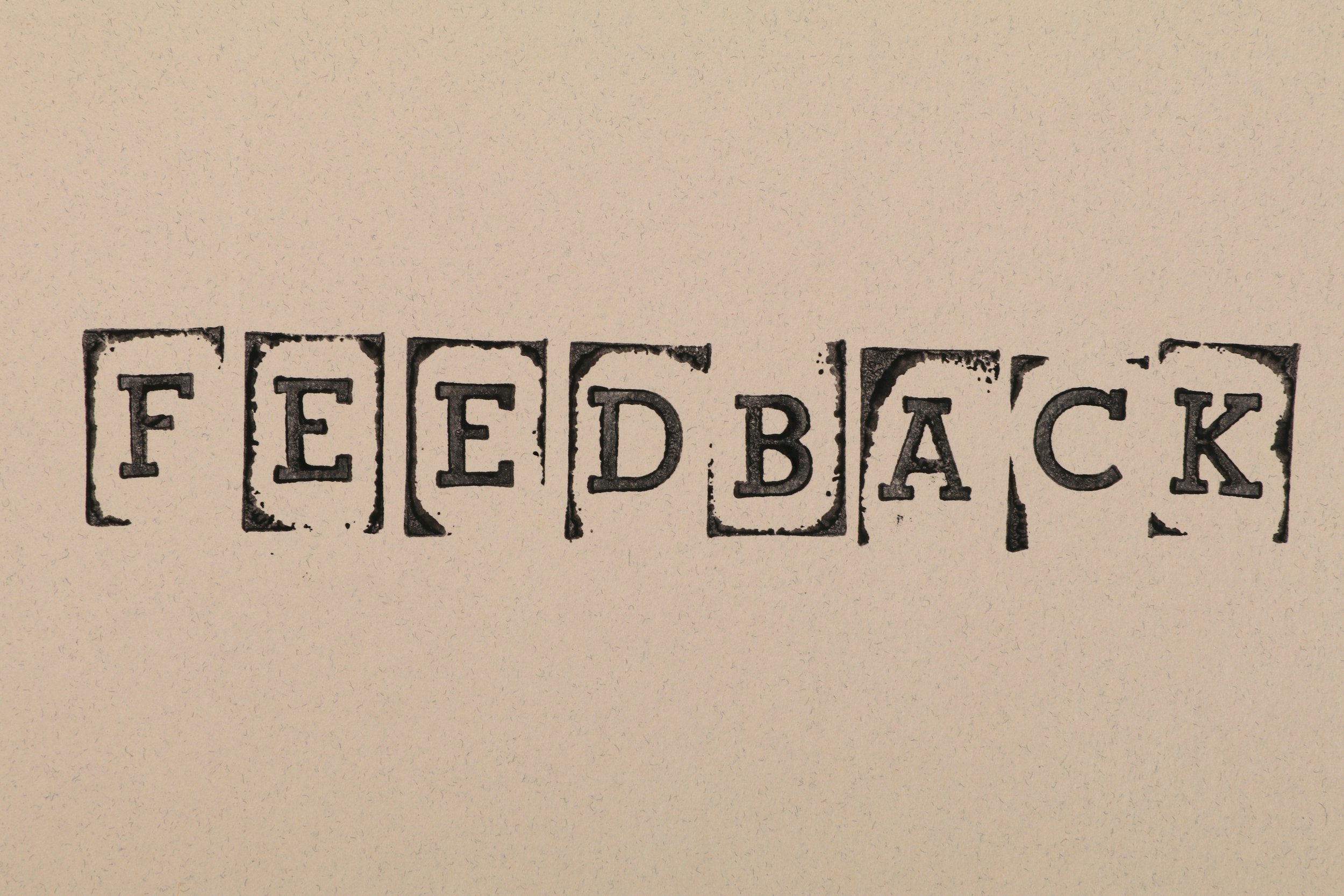 The word "feedback" is spelt out using individual wooden stamps.