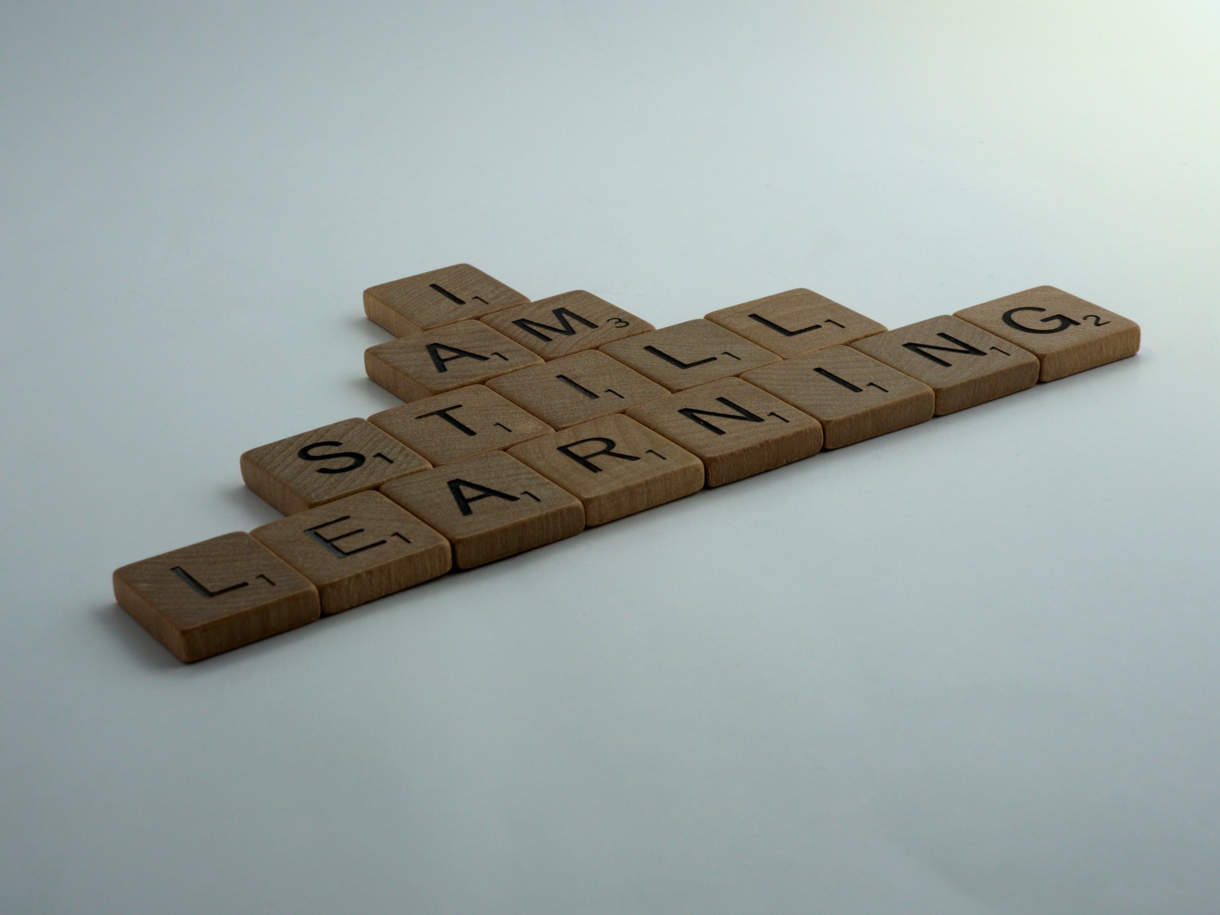 "I am still learning" is written in wooden letter tiles.